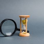 Magnifying glass and hourglass. Search for time and resources. Streamline business, increase efficiency and reduce downtime. Find in the shortest possible time. Effective business solutions