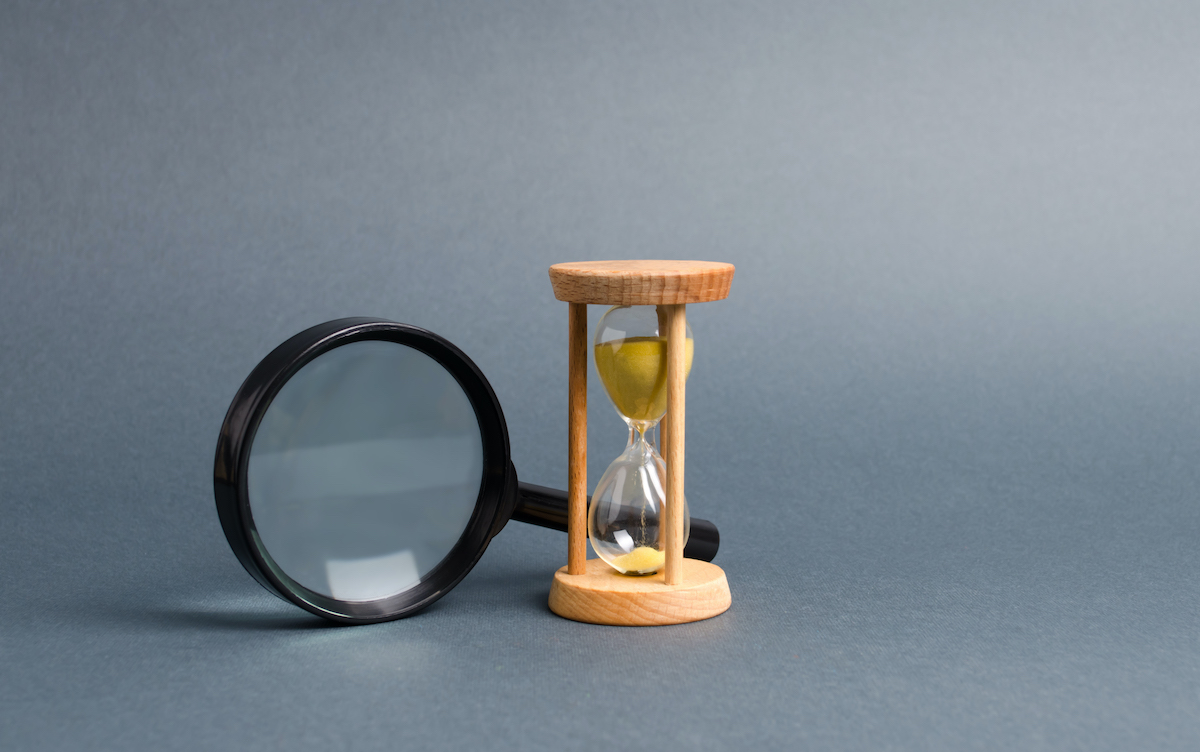 Magnifying glass and hourglass. Search for time and resources. Streamline business, increase efficiency and reduce downtime. Find in the shortest possible time. Effective business solutions